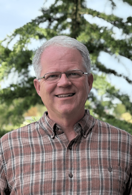 Smiling older man in plaid shirt outdoors